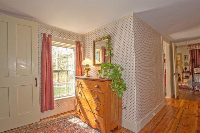interior space featuring ornamental molding, wallpapered walls, and light wood finished floors