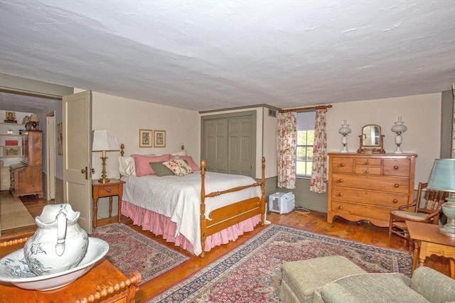 bedroom with wood finished floors and a closet