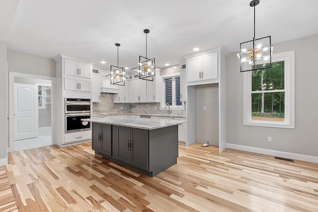 168 Justice Hill Rd Oakmont, Unit Oakmont, Sterling, MA 01564 - kitchen with a chandelier, double oven, white cabinetry, a sink, and light wood-type flooring
