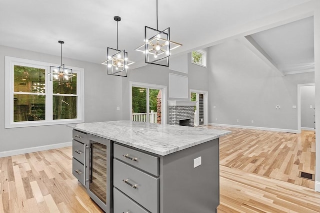 168 Justice Hill Rd Oakmont, Unit Oakmont, Sterling, MA 01564 - kitchen featuring gray cabinets, beverage cooler, a chandelier, and light wood-style floors