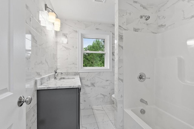 168 Justice Hill Rd Oakmont, Unit Oakmont, Sterling, MA 01564 - bathroom with marble look tile flooring, toilet, vanity, tile walls, and washtub / shower combination