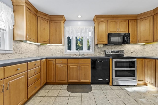 kitchen featuring a sink, brown cabinets, black appliances, and light tile patterned floors