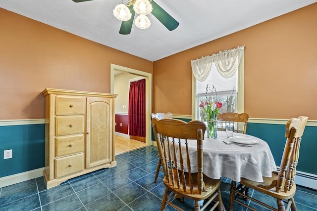 dining room with dark tile patterned flooring, baseboards, and ceiling fan