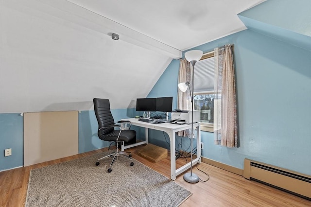 office space with a baseboard heating unit, vaulted ceiling, and wood finished floors