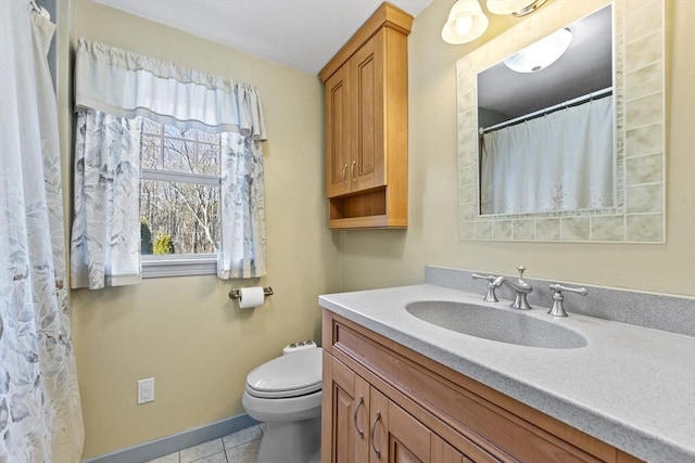 bathroom with baseboards, toilet, vanity, and tile patterned flooring