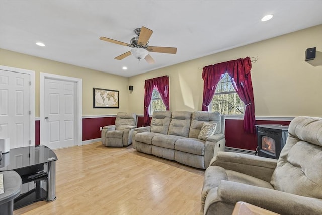 living room with ceiling fan, recessed lighting, light wood-style flooring, and a wood stove