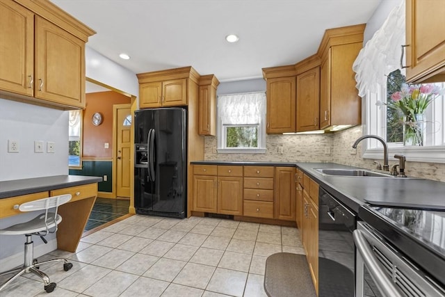 kitchen with light tile patterned floors, decorative backsplash, black appliances, and a sink