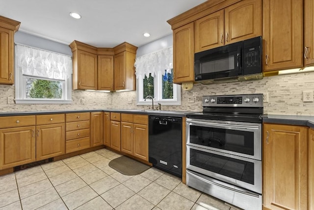 kitchen featuring a sink, backsplash, black appliances, and light tile patterned flooring