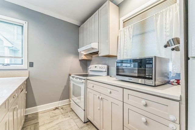 328 E Main St, Marlborough, MA 01752 - kitchen with white range with electric cooktop, stainless steel microwave, under cabinet range hood, light wood finished floors, and light countertops