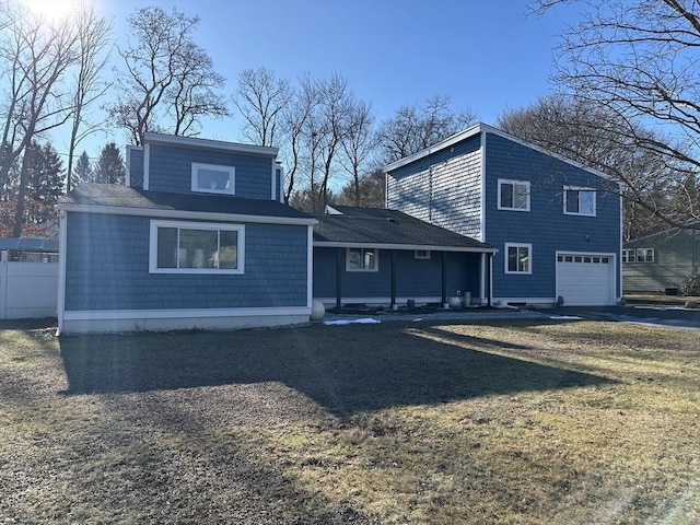 rear view of house with a garage and a yard