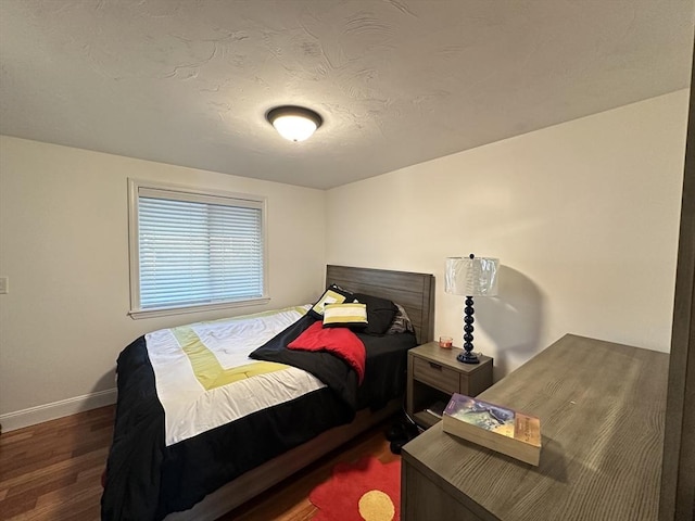 bedroom featuring dark hardwood / wood-style flooring and a textured ceiling