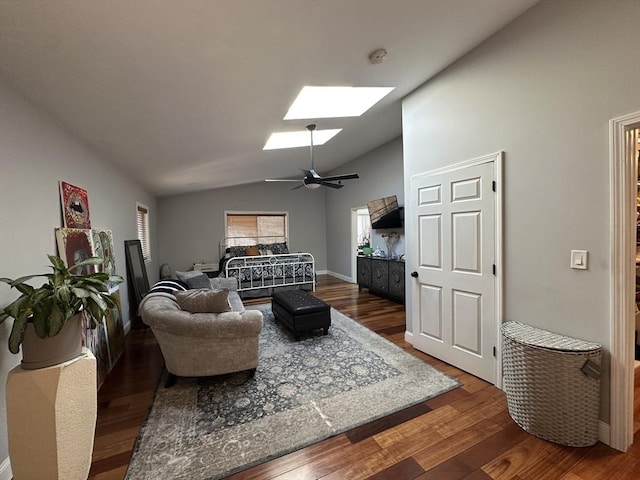 living room featuring ceiling fan, vaulted ceiling with skylight, and dark hardwood / wood-style floors