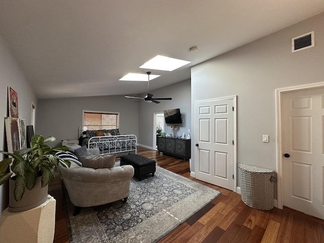 living room with ceiling fan, dark hardwood / wood-style flooring, and vaulted ceiling with skylight