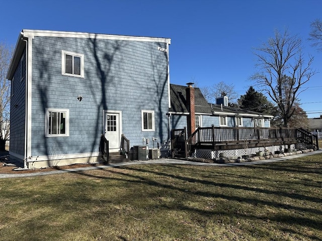 back of house featuring a lawn, central AC unit, and a wooden deck