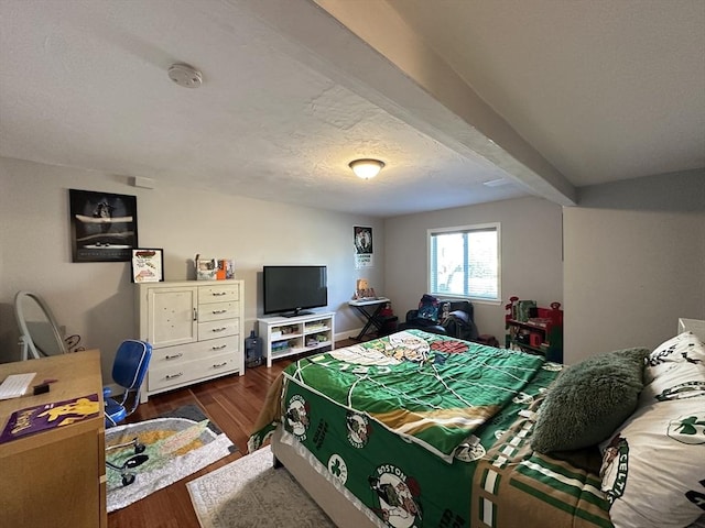 bedroom with a textured ceiling, beam ceiling, and dark hardwood / wood-style floors