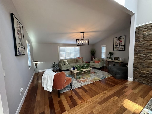 living room featuring a notable chandelier, lofted ceiling, and wood-type flooring