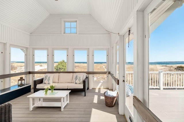 sunroom featuring a beach view, an outdoor living space, and a water view