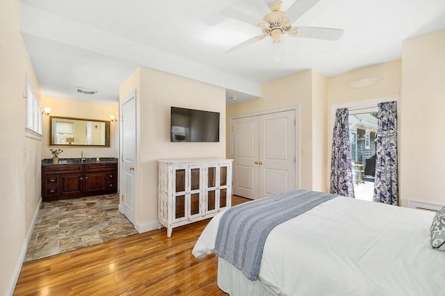 bedroom with multiple windows, wood finished floors, and baseboards
