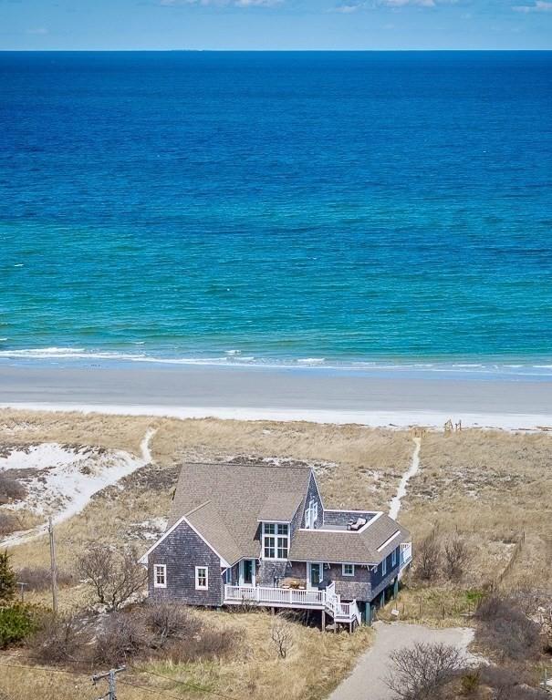 drone / aerial view featuring a water view and a view of the beach
