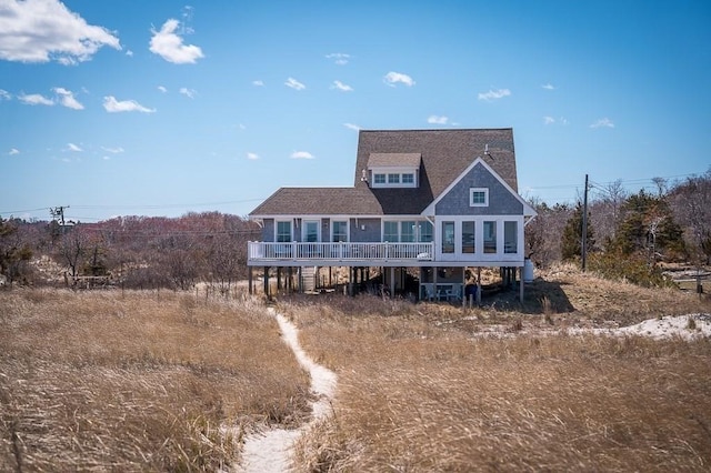 back of property featuring a deck and roof with shingles