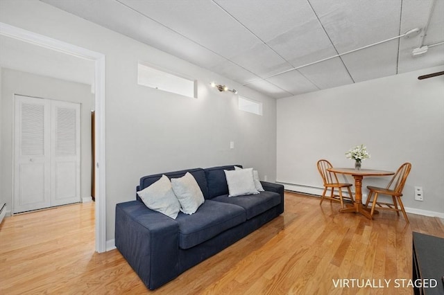 living room with baseboard heating and wood-type flooring