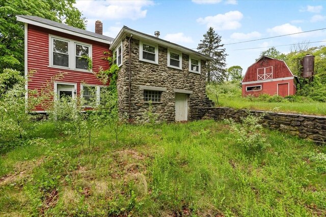 21 City Depot Rd, Charlton, MA 01507 - rear view of property featuring a barn, stone siding, a chimney, and an outbuilding