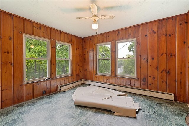 21 City Depot Rd, Charlton, MA 01507 - empty room with wood finished floors, baseboard heating, wooden walls, and a ceiling fan
