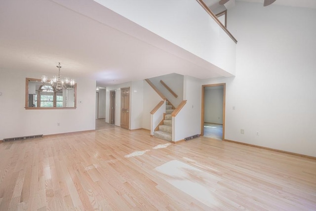 19 Spruce Pond Rd Unit 19, Franklin, MA 02038 - unfurnished living room with light wood finished floors, stairway, a chandelier, and baseboards
