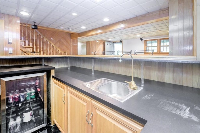 19 Spruce Pond Rd Unit 19, Franklin, MA 02038 - kitchen with beverage cooler, dark countertops, a sink, light brown cabinetry, and wooden walls