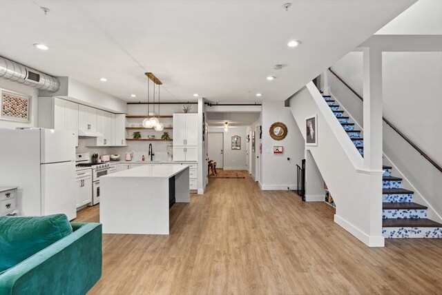 17 Kearney Sq Unit 209, Lowell, MA 01852 - kitchen with freestanding refrigerator, open shelves, double oven range, a sink, and light wood-style floors