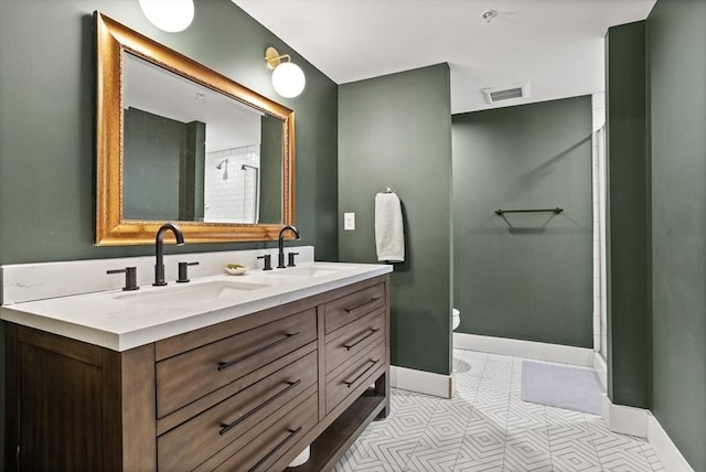 17 Kearney Sq Unit 209, Lowell, MA 01852 - bathroom featuring double vanity, toilet, baseboards, and a shower with door