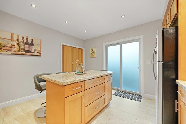 540 Rivet St, New Bedford, MA 02740 - kitchen with freestanding refrigerator, recessed lighting, a center island, baseboards, and a breakfast bar area