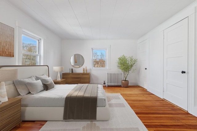 bedroom with radiator and light wood-type flooring