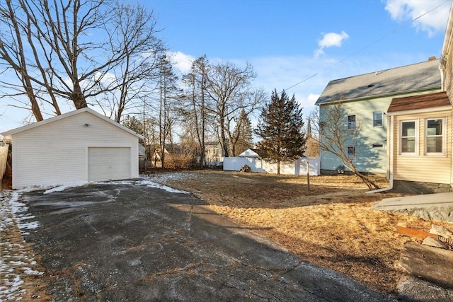 exterior space featuring a garage and an outbuilding