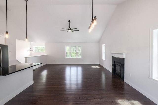 40 Jackson Ln, Barre, MA 01005 - unfurnished living room with ceiling fan, high vaulted ceiling, a glass covered fireplace, dark wood-style flooring, and baseboards