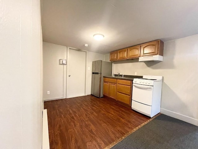 kitchen with sink, stainless steel fridge, white range oven, and dark wood-type flooring