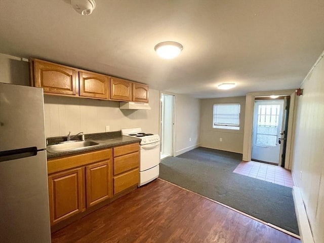 kitchen featuring white stove, dark wood-type flooring, sink, stainless steel fridge, and a baseboard radiator