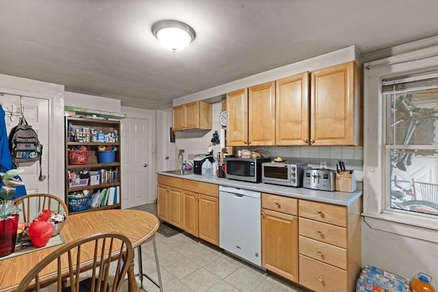 kitchen featuring decorative backsplash, light brown cabinets, and white dishwasher