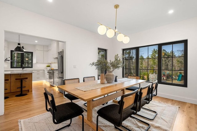 dining room featuring a chandelier, recessed lighting, baseboards, and light wood-style floors