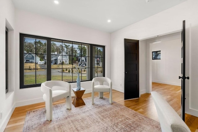 living area with recessed lighting, wood finished floors, and baseboards