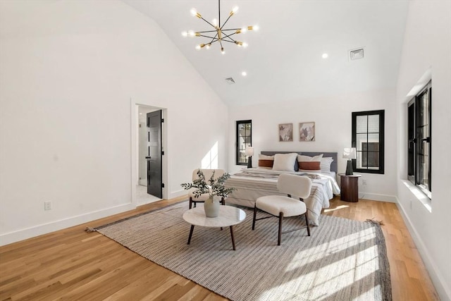 bedroom featuring baseboards, visible vents, light wood finished floors, and high vaulted ceiling