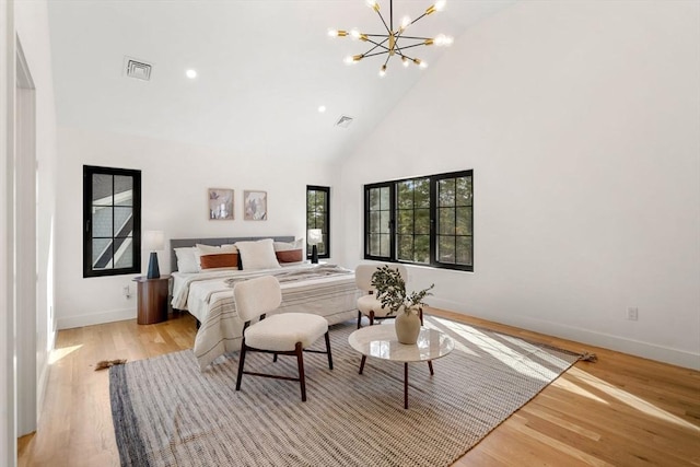 bedroom featuring an inviting chandelier, high vaulted ceiling, visible vents, and light wood-type flooring