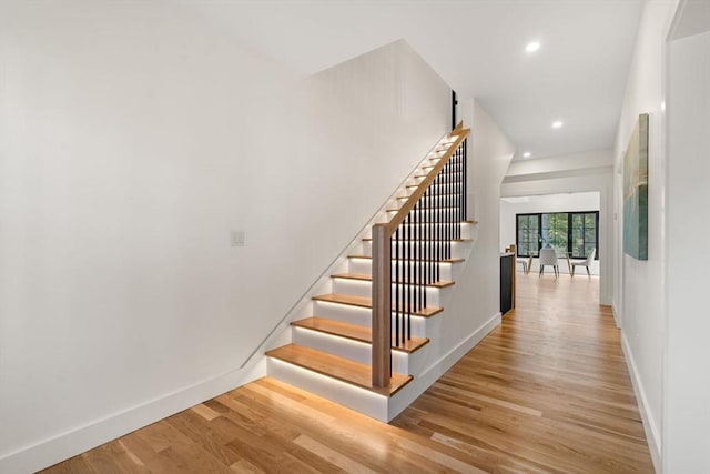 stairway featuring recessed lighting, baseboards, and wood finished floors