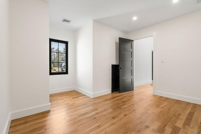 spare room with visible vents, baseboards, and light wood finished floors