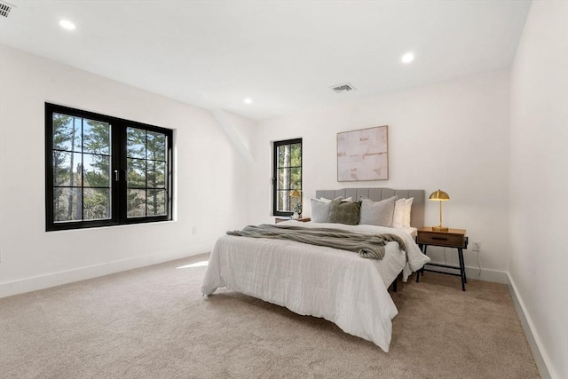 bedroom with recessed lighting, light colored carpet, visible vents, and baseboards