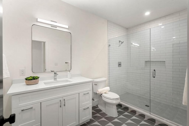 bathroom featuring vanity, toilet, and a shower stall