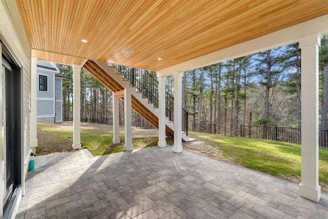 view of patio featuring stairs and fence