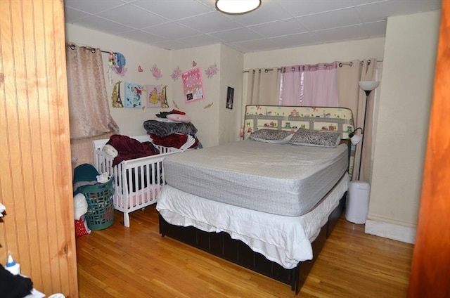 bedroom featuring a paneled ceiling and hardwood / wood-style floors