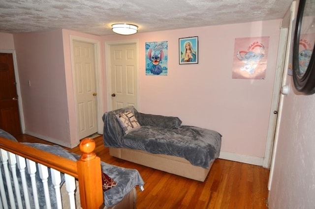 bedroom featuring a textured ceiling and hardwood / wood-style floors