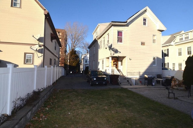 rear view of property featuring a patio area and a yard